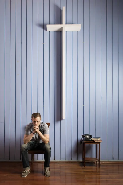 Депресивний Чоловік Молиться Стільці Білим Хрестом Висить Синій Дерев Яній — стокове фото