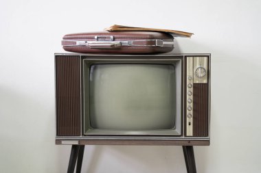 Beyaz odadaki eski televizyondaki eski model evrak çantası.
