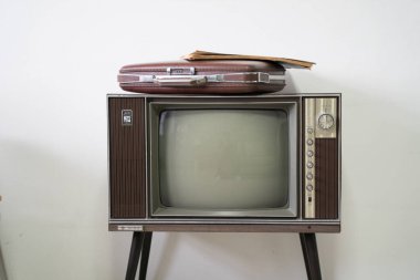 Beyaz odadaki eski televizyondaki eski model evrak çantası.