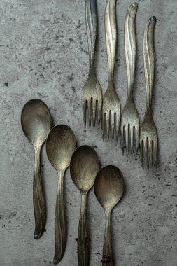 Eski paslı çatallar ve kaşıklar grunge gri arka planda