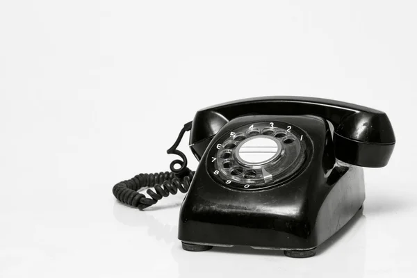 Beyaz üzerine eski model siyah telefon.