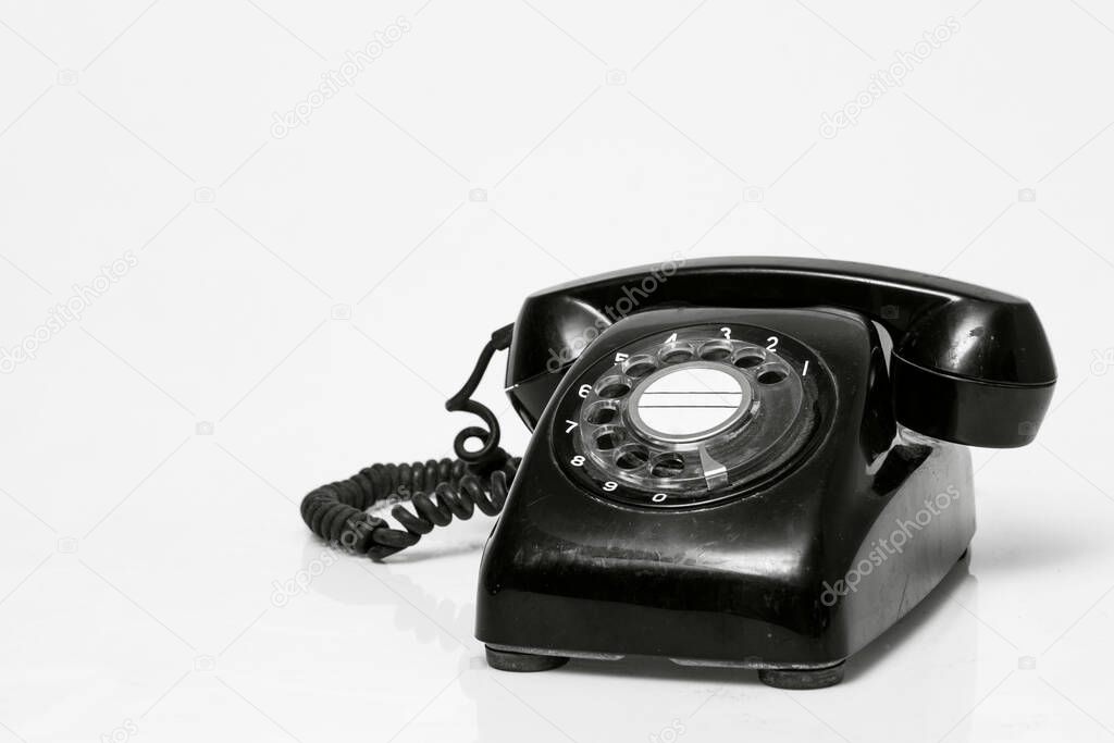 Old vintage black telephone on white