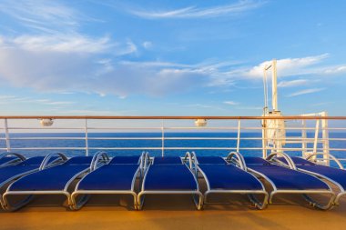 Sakin mavi denizin arka planında çit boyunca uzanan havuz kenarları.