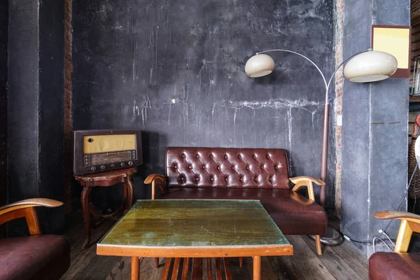 Rustic industrial loft style interior sofa with vintage radio by the wall, all logo and trademark removed