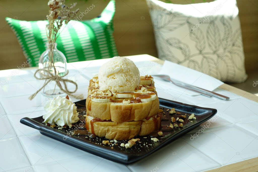 Honey banana toast with vanilla ice cream served on white table