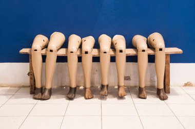 Oturma pozisyonunda yapay bacaklar duvara karşı dururlar..