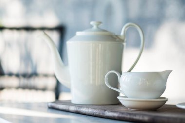 Beyaz çay demliği ve fincanı granit masaya koyun.