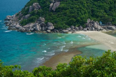 Dağın arka planında dalgalar sahile vuruyor. Koh Nangyuan Tayland sahilinin yukarısından hava fotoğrafçılığı.