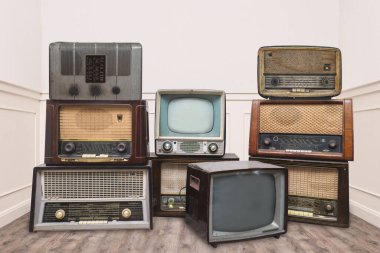 Vintage radios and televisions in a room clipart