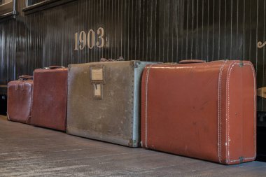 Duvarın yanında deri çantalar.