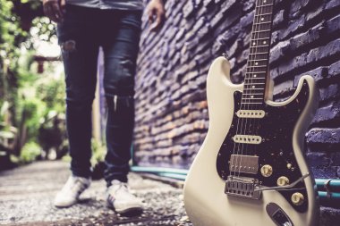 Genç adam elektro gitara doğru yürüyor.