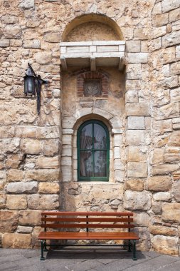 Ahşap bank ve pencereli taş duvar ve meşale lambası. İtalyan klasik tarzı dış görünüş