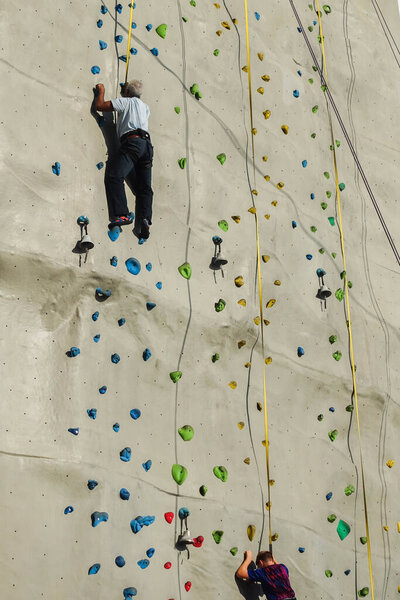 A man practicing rock climbing on artificial wall indoors. Active lifestyle and bouldering concept.