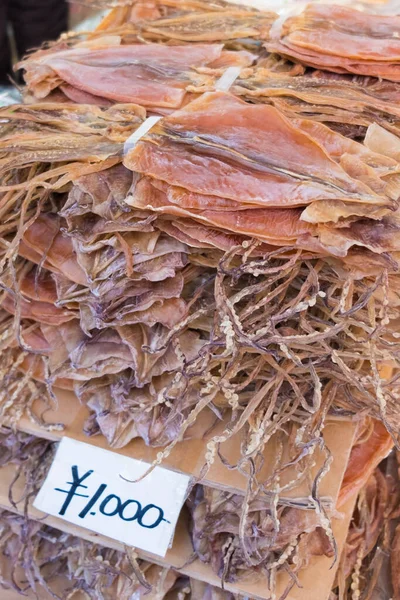 日本円で値札付きの日本市場で販売されている乾燥イカのスタック 1000円 — ストック写真