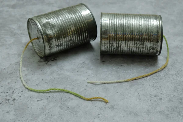 ロープが切断されたと灰色の背景に錫缶電話 コンセプト切断通信 — ストック写真