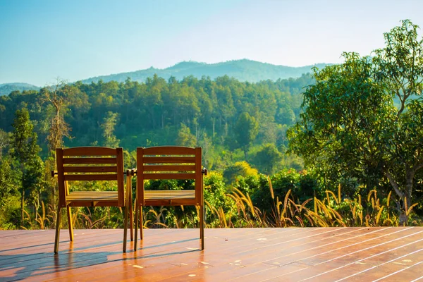 empty chairs on terrace with mountains on background