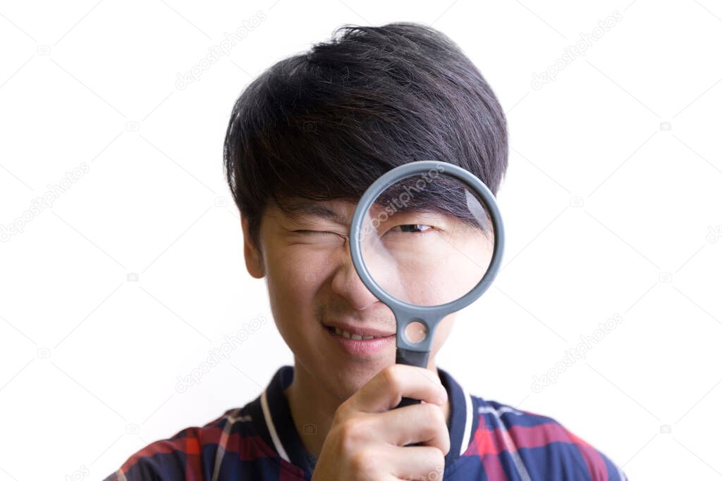 Asian young man searching through magnification glass on white background