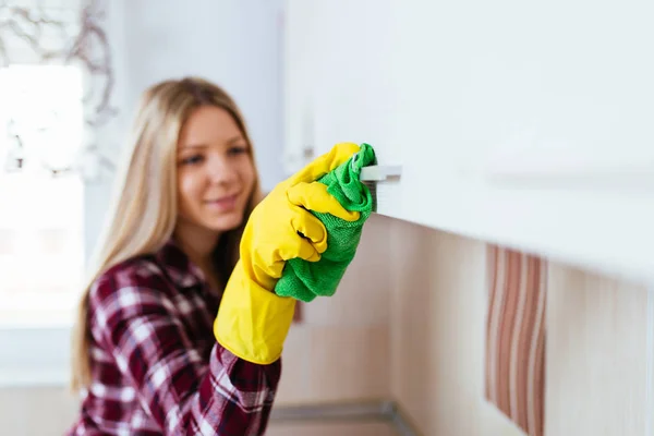 Beautiful young smiling woman cleaning house.