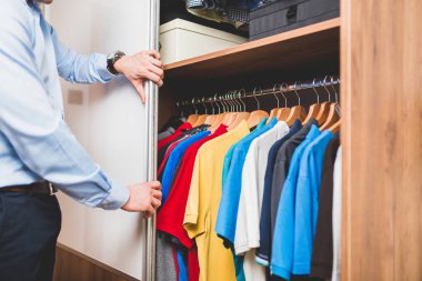 Genç adam t-shirt gardırop seçme.