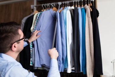 Genç adam gömlek gardırop seçme.