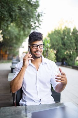 Genç yakışıklı Afro Amerikan oturma bina, kartvizit holding ve bazı işlerini laptop önünde büyük modern iş dostum. Seçici odak üstünde el.