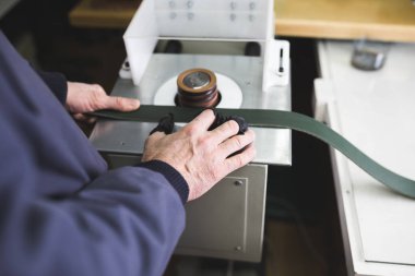 Deri kemer yapım süreci işçi elinde kadeh kapatın. Seçici odak.