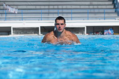  Genç adam yüzme havuzunda yüzüyor..