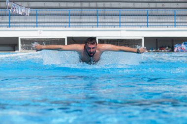  Genç adam yüzme havuzunda yüzüyor..