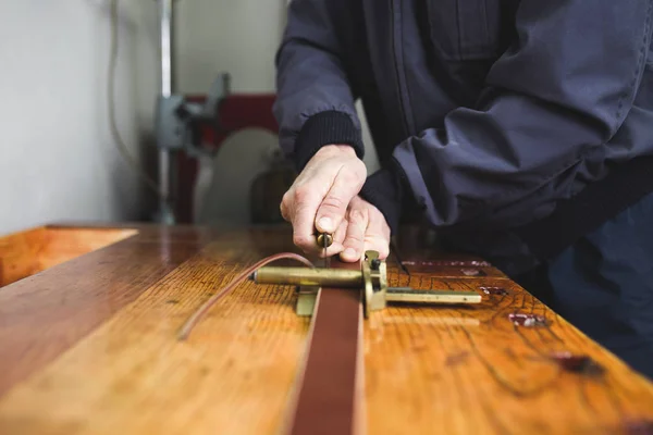 Close up shot of worker\'s hands in leather belt making process. Selective focus.