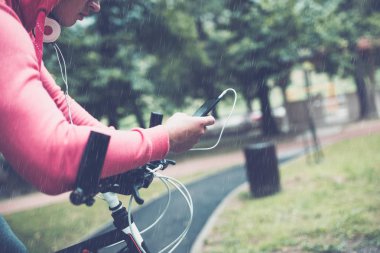 adam cep telefonu ararken bir parkta bisikletle