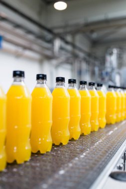 İçerideki sanayi fabrikaları ve makineler. Soda ve portakal suyu şişelerini işlemek ve şişelemek için robot fabrikası hattı.
