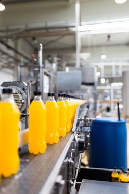 İçerideki sanayi fabrikaları ve makineler. Soda ve portakal suyu şişelerini işlemek ve şişelemek için robot fabrikası hattı.