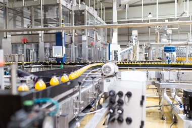 İçerideki sanayi fabrikaları ve makineler. Soda ve portakal suyu şişelerini işlemek ve şişelemek için robot fabrikası hattı.