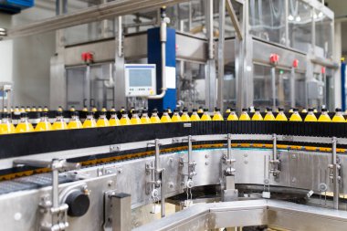 İçerideki sanayi fabrikaları ve makineler. Soda ve portakal suyu şişelerini işlemek ve şişelemek için robot fabrikası hattı.