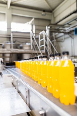 İçerideki sanayi fabrikaları ve makineler. Soda ve portakal suyu şişelerini işlemek ve şişelemek için robot fabrikası hattı.