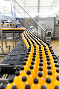 İçerideki sanayi fabrikaları ve makineler. Soda ve portakal suyu şişelerini işlemek ve şişelemek için robot fabrikası hattı.