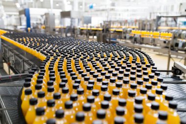 İçerideki sanayi fabrikaları ve makineler. Soda ve portakal suyu şişelerini işlemek ve şişelemek için robot fabrikası hattı.
