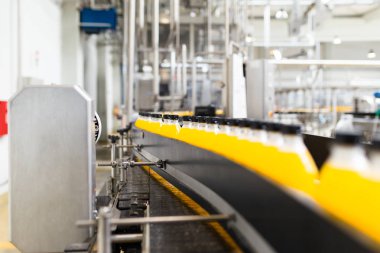İçerideki sanayi fabrikaları ve makineler. Soda ve portakal suyu şişelerini işlemek ve şişelemek için robot fabrikası hattı.