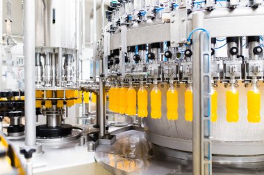 İçerideki sanayi fabrikaları ve makineler. Soda ve portakal suyu şişelerini işlemek ve şişelemek için robot fabrikası hattı.