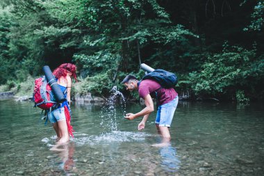 Genç mutlu çift birlikte vahşi dağ nehirde zevk. 