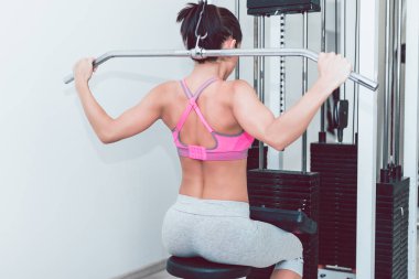 Fitness salonunda egzersiz yapıyor güzel ve çekici genç esmer kadın.
