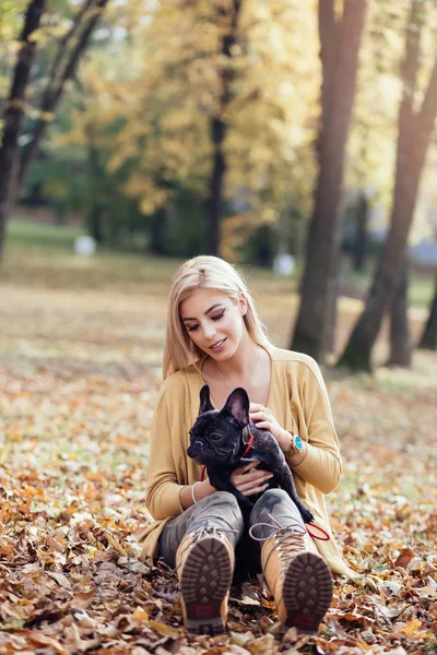 美しく 幸せな女性の彼女の愛らしいフレンチ ブルドッグと楽しむ公園で楽しんで 秋の時間 — ストック写真