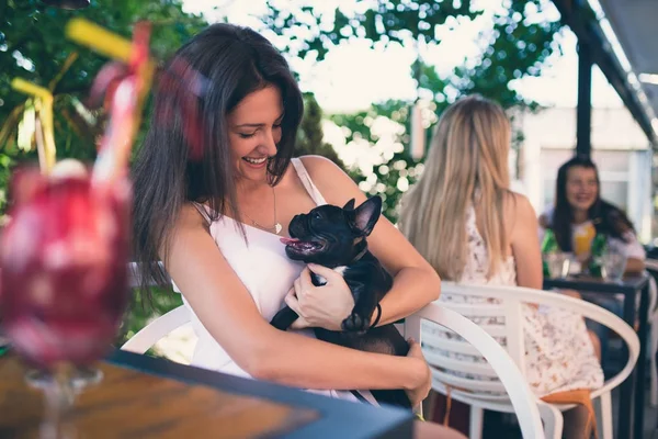 若いです女性楽しみますカフェテリアで維持可愛いですフランスのブルドッグ子犬 — ストック写真