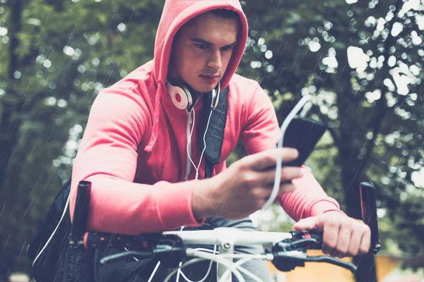 adam cep telefonu ararken bir parkta bisikletle