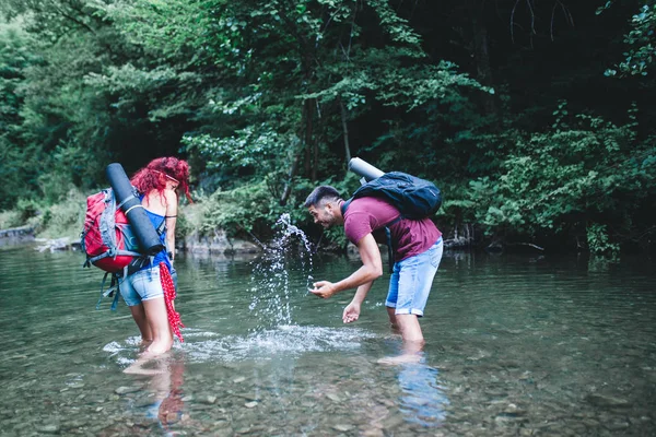 Genç mutlu çift birlikte vahşi dağ nehirde zevk. 