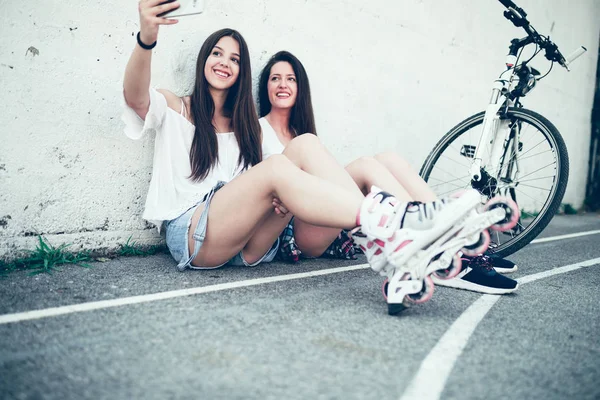 İki genç ve güzel kız selfie alıyor. İlk kız üzerinde odaklanmıştır. Eski film bakmak.