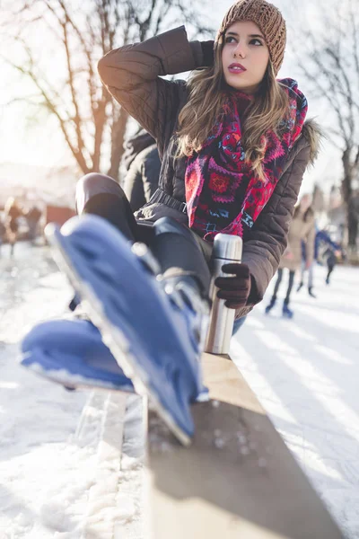 Buz pateni pistinde güzel bir genç bayan. Paten seçmeye odaklan.