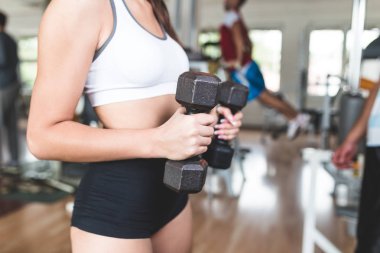Egzersiz ve fitness spor salonunda ağırlık kaldırma işi çekici genç kadın. Fitness ve sağlık kavramı.