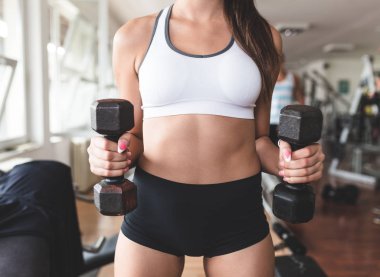 Egzersiz ve fitness spor salonunda ağırlık kaldırma işi çekici genç kadın. Fitness ve sağlık kavramı.