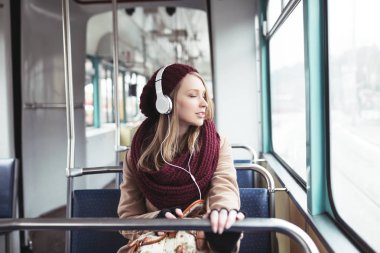 Müzik tramvay içinde oturan güzel genç kadın 